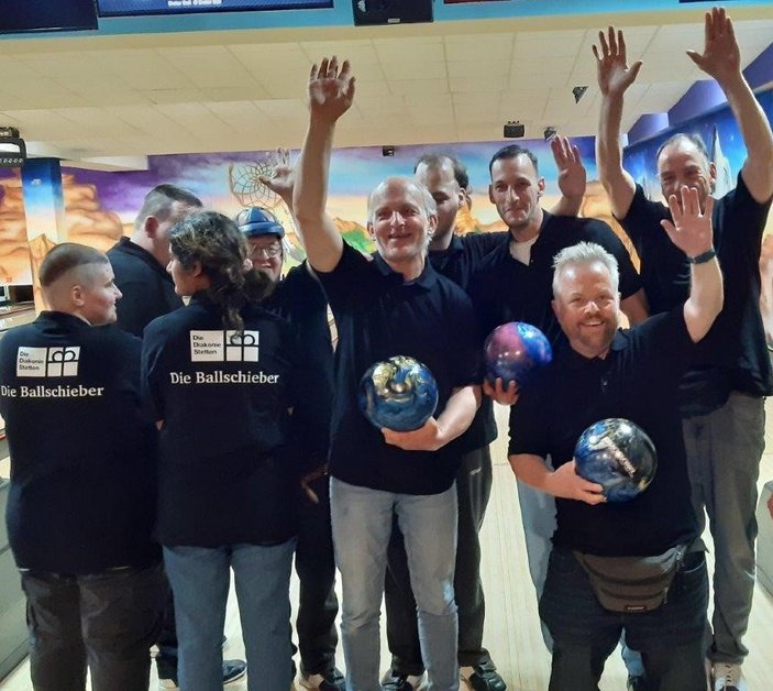 Bowlinggruppe winkt in die Kamera