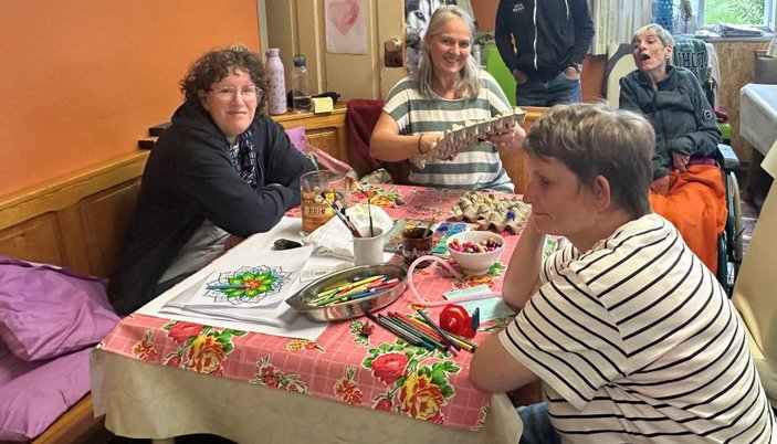 Menschen sitzen am Tisch und basteln
